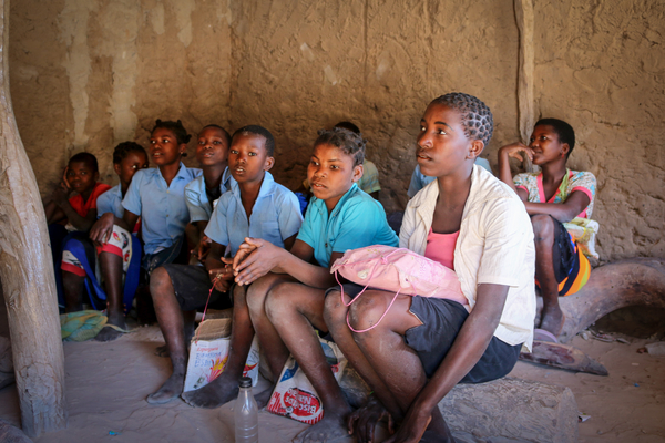 Children sitting in the dirt in class in Mozambique