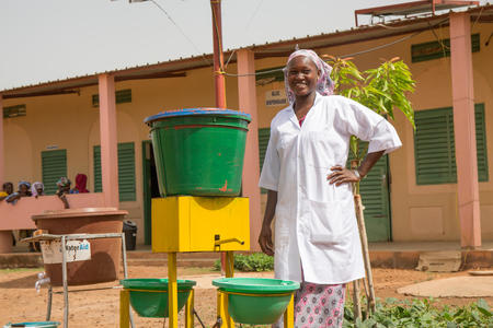 Korotimi Dembele, Pharmacy Manager, next to a handwashing device in front of the community clinic block in Bougoura Communal Health Centre, Bougoura Village, Commune of Yangasso, Circle of Bla, Region of Segou, Mali. May 2017.