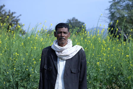 Chunkawan, 55, stands in his field in Gidurah Village, Chitrakoot, Uttar Pradesh, India