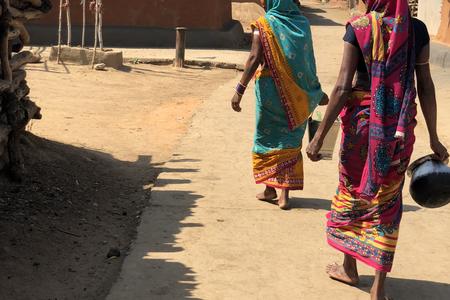 Hrudamajhi and her neighbours walk towards the dug well
