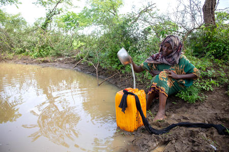 Amina Abdi, 25, collecting water from unprotected water source which is about three hours walk from her house, Sirima village, Berbere District, Bale Zone, Oromia Regional State, Ethiopia, May 2022.