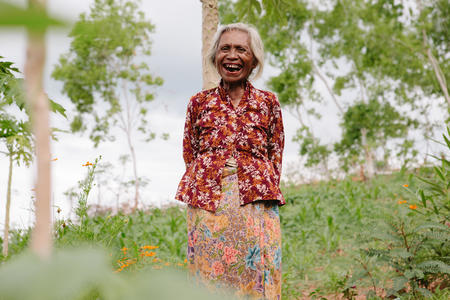 Alzira waters her garden in Timor Leste.