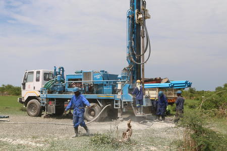 Men drill a borehole at a primary school in Zambia.