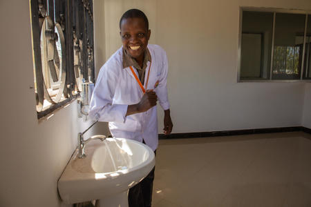 Dr. Casmir Lubango, 36, medical officer, testing the functionality of the newly installed piped water system in the new maternity ward at Kharumwa Health Centre, Nyang'hwale District, Tanzania, June, 2019.