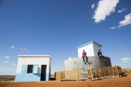 A view of the water tank and the water treatment section with Moïse, 29 and Toky, 33. Firaisantsoa Imanga village, Tsinjoarivo Imanga commune, Tsiroanomandidy district, Madagascar, June 2018.