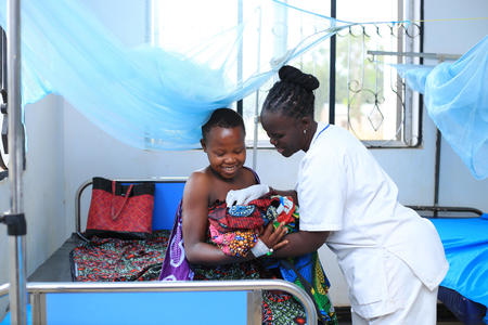 Everlyne, a Nurse at Kharumwa Health Centre, attending to a patient in the Geita region of Tanzania.